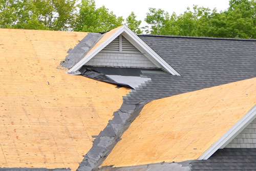 A shingled roof with visible damage