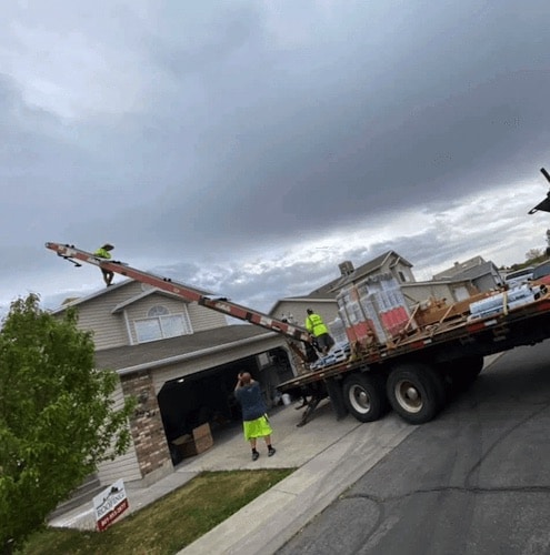 A truck parked in front of a house with a sign 'We Do Roofing in Salt Lake City Utah Company'.