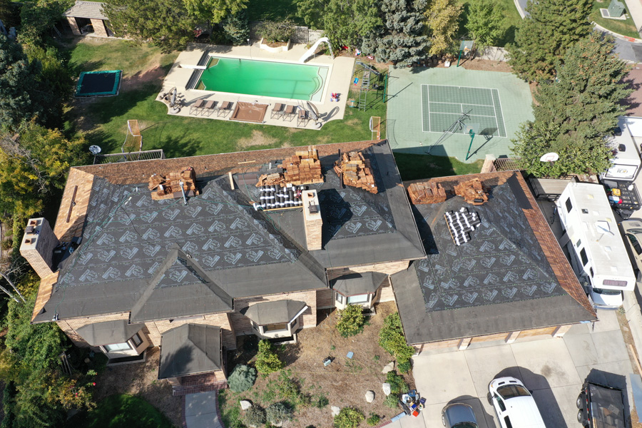 Aerial view of a house with a pool, showcasing a beautiful landscape. We specialize in roofing installation.