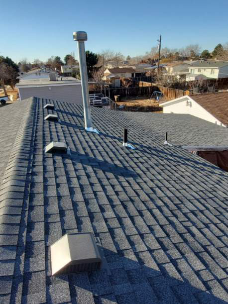 Roofing professionals working together to install a new roof, ensuring each shingle is properly secured for durability