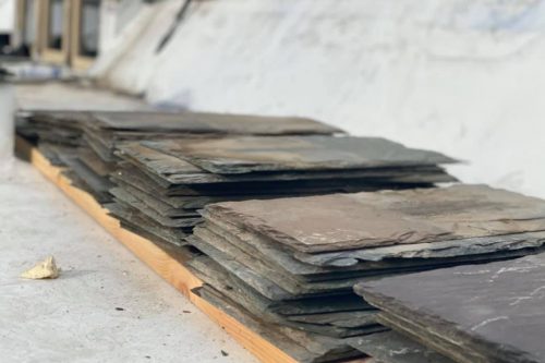 A stack of slate on a wooden pallet, ready for use in construction or decoration.